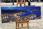 One of Marianne Skjelbred's paintings on an easel just outside her gallery, with the entrance to the Fløibanen funicular in the background.